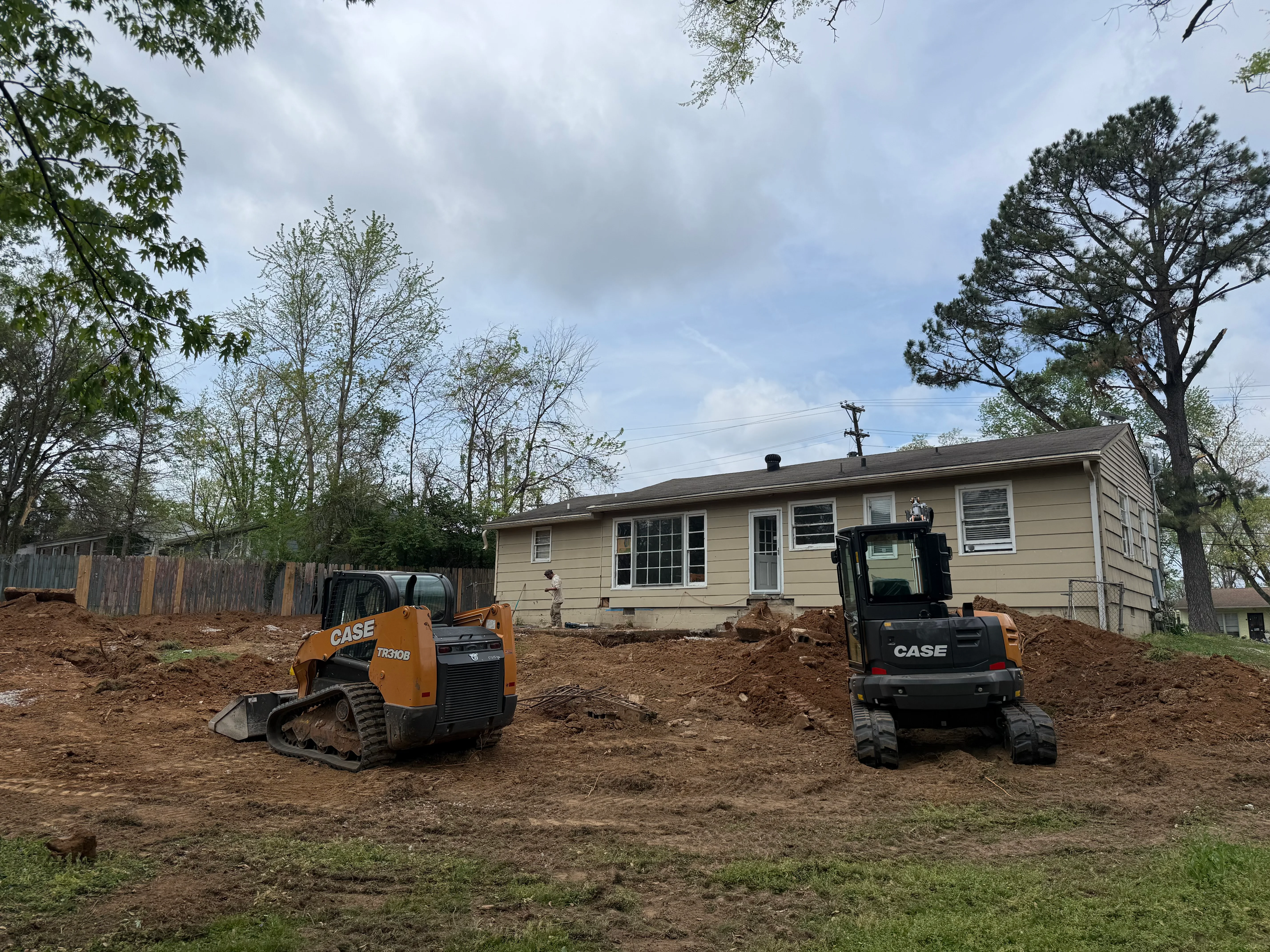 Excavator grading residential lot for new construction
