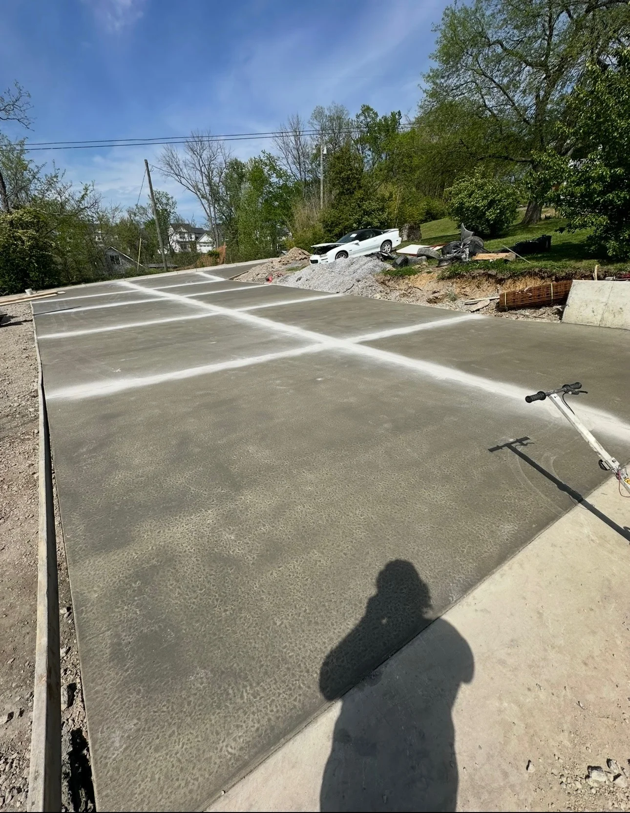 Freshly poured concrete foundation with control joints and metal forms on residential construction site